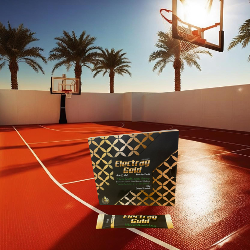 Electrag Gold electrolyte powder box on an outdoor sports court under intense Dubai sun, representing luxury hydration and energy for athletes.