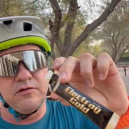 Male cyclist outdoors in a Dubai park holding Electrag Gold sachet – sugar-free hydration powder for endurance, recovery, and Gulf heat.