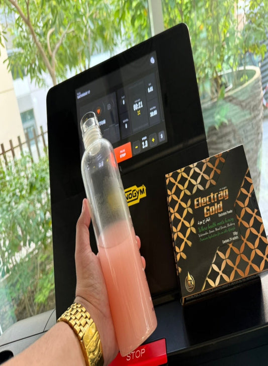 Electrag Gold sachet and water bottle placed on a treadmill at the gym, perfect hydration for workouts in Dubai